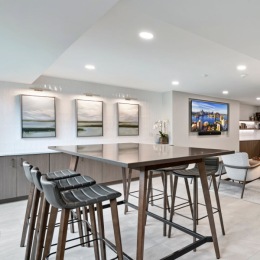 a lounge with seating tables and tv