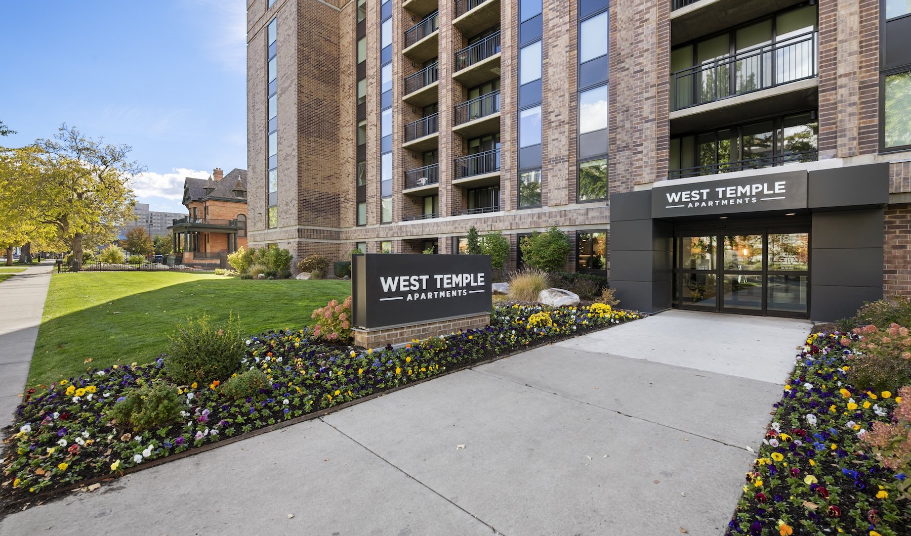 the front of a building with a sign and a path